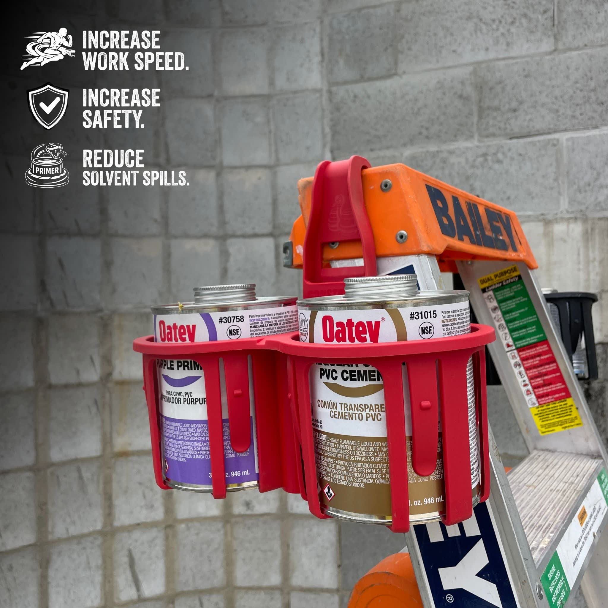 Red can holder with Oatey paint cans on a ladder against a brick wall.